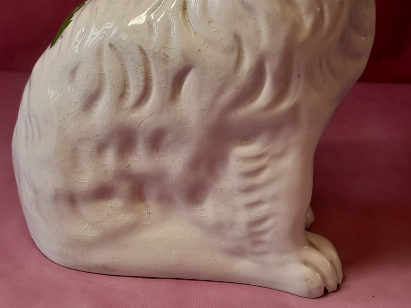 Zittende hond in wit gevlekt porselein