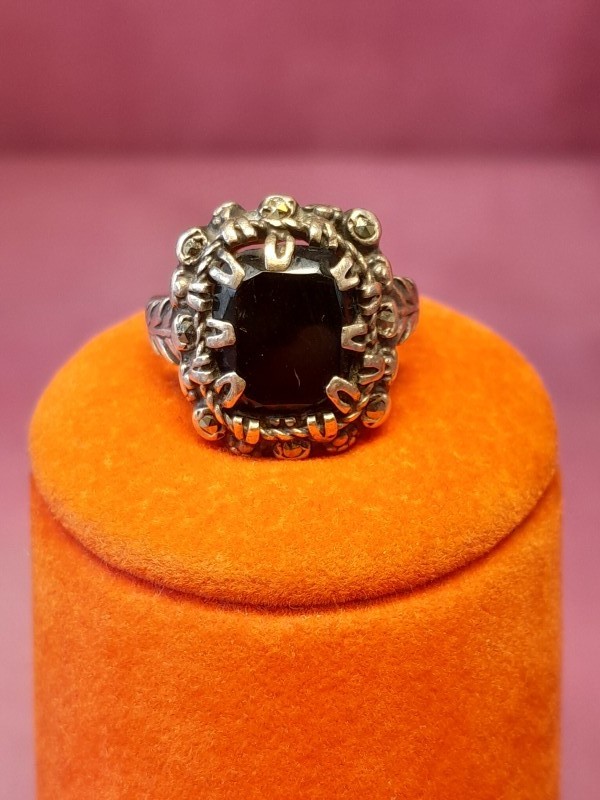 Zilveren ring zwarte steen met een floraal motief