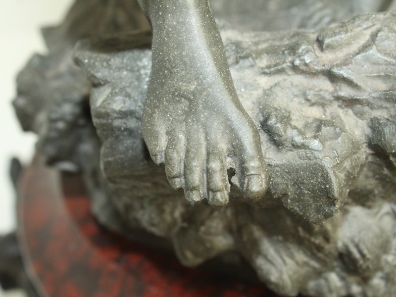 Metalen sculptuur op roodmarmeren voet met klok